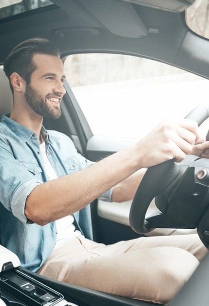 A man sitting in the driver 's seat of his car.